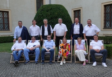 Gruppenfoto der Geschäftsführer*innen im Innenhof des St. Pöltner Doms auf Liegestühlen